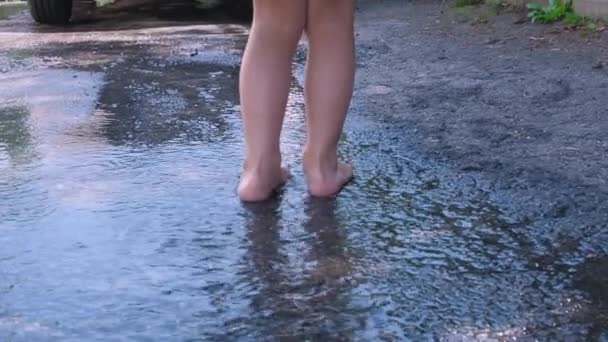 Pfütze Auf Dem Bürgersteig Regentropfen Fallen Ins Wasser Barfüßige Babys — Stockvideo