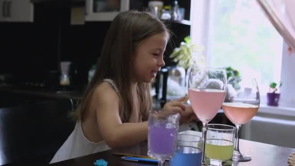 小さい女の子 トッドラーは台所の水のガラスでドラムスティックで音楽を演奏する 高品質の写真 — ストック動画