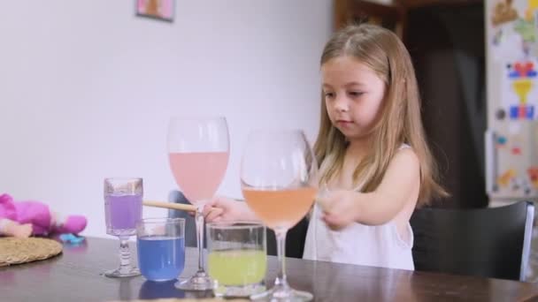 Κοριτσάκι Νήπιο Παίζει Μουσική Ποτήρια Νερό Ενάντια Στην Κουζίνα Υψηλής — Αρχείο Βίντεο