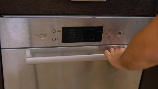 若い男が食器洗い機を閉め モードを選択して始める 高品質のフルHd映像 — ストック動画