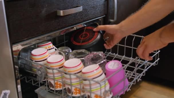 Junger Mann Stellt Schmutzige Tassen Die Spülmaschine Der Küche Haushalts — Stockvideo