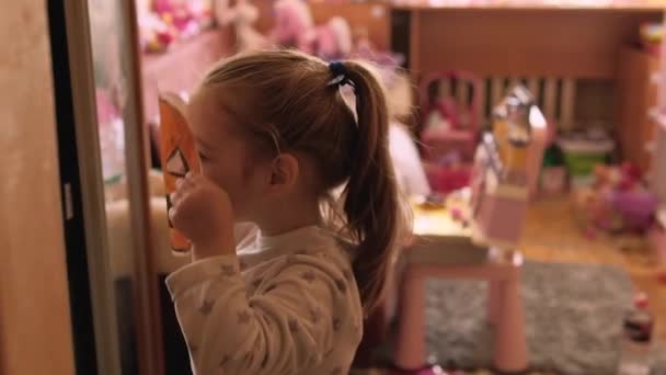 Κοριτσάκι Δοκιμάζει Μια Χειροποίητη Χάρτινη Μάσκα Κολοκύθας Μπροστά Από Έναν — Αρχείο Βίντεο