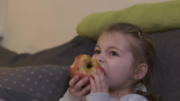 Klein Meisje Zit Keuken Aan Tafel Eet Een Grote Sappige — Stockvideo