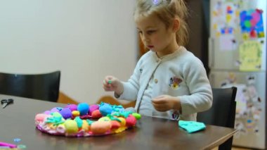 Çocuk elleri, boncuklarla hamur dekorasyonundan paskalya yumurtası yapıyor. Paskalya için şirin çocuk el sanatları. Çocuklar için Tatil Sanatı Etkinliği. Güzel motor beceriler, yaratıcılık ve hobi. Yüksek kalite fotoğraf