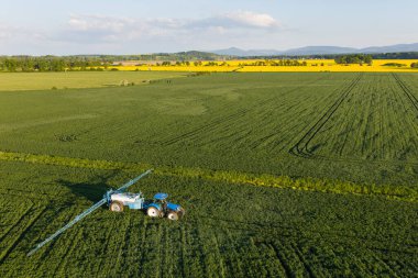 Polonya 'nın Nysa kenti yakınlarındaki hasat alanındaki traktörün hava görüntüsü.