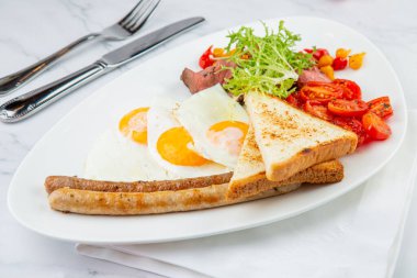 Çırpılmış yumurta, sebze, kiraz domates, ekmek, bitki ve sosis.