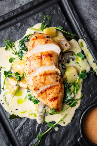 baked chicken fillet in creamy sauce with herbs
