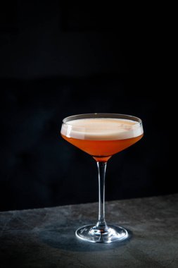 Martini bardağında köpüklü tropik kokteyl.