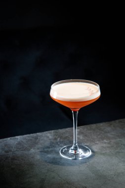 Martini bardağında köpüklü tropik kokteyl.