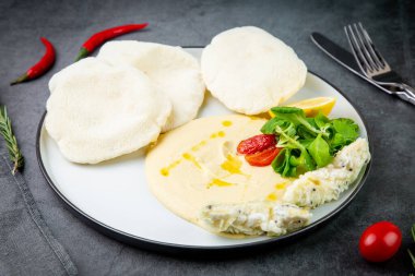 Pirinçli balık bifteği, kiraz domatesleri, limon ve otlar.