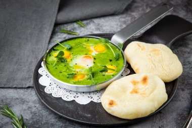 Kızartma tavasında kremalı brokoli çorbası ve koyu arkaplanda tortilla.