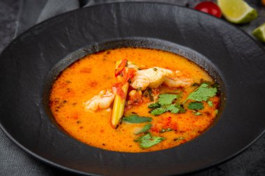 Sebzeli siyah tabakta baharatlı Tom yum.