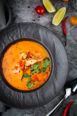 Sebzeli siyah tabakta baharatlı Tom yum.