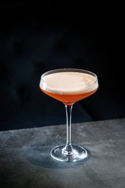 Koyu arkaplanda martini bardağında tropikal kokteyl