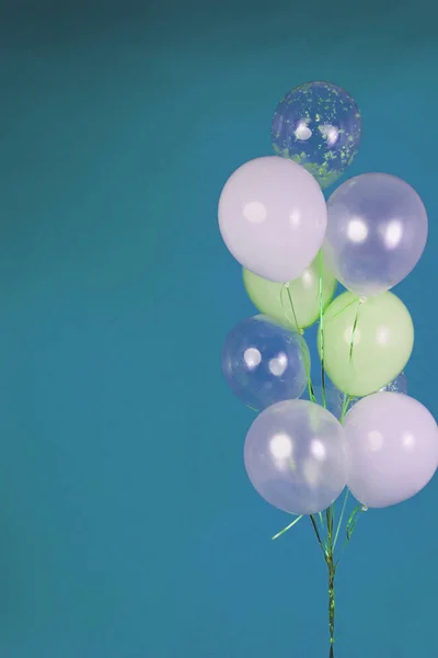 Balloons of light colors - white, light green, transparent on a blue background. High quality photo