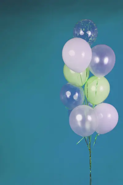 Balloons of light colors - white, light green, transparent on a blue background. High quality photo