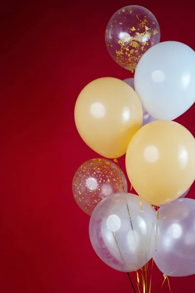 A bunch of light balloons on a red background. Vertical Photo Space for Text. High quality photo