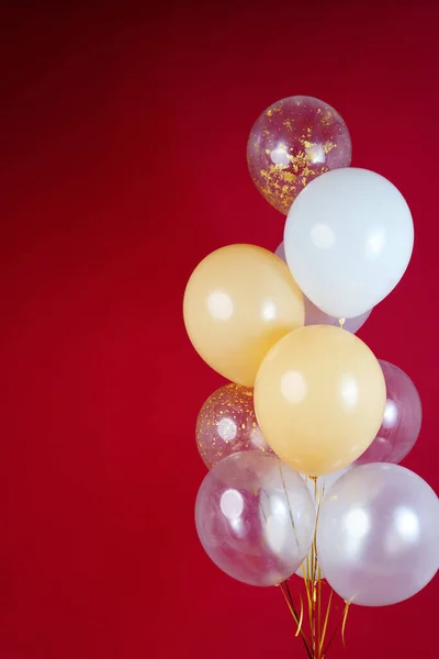 A bunch of light balloons on a red background. Vertical Photo Space for Text. High quality photo