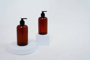 Arka planda sabun spreyi olan iki siyah şişe, bir stantta. Beyaz arka planda izole edilmiş. Yüksek kalite fotoğraf