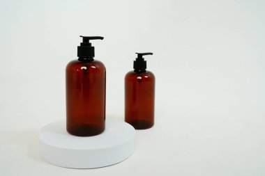 Arka planda sabun spreyi olan iki siyah şişe, bir stantta. Beyaz arka planda izole edilmiş. Yüksek kalite fotoğraf