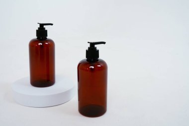 Arka planda sabun spreyi olan iki siyah şişe, bir stantta. Beyaz arka planda izole edilmiş. Yüksek kalite fotoğraf