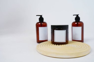 Vücut bakımı. Geometrik bir tezgahta açık gri arka planda, üzerinde şeker kutusu ve bir kavanoz vücut kremi olan iki şişe. Reklam konsepti. Yüksek kalite fotoğraf