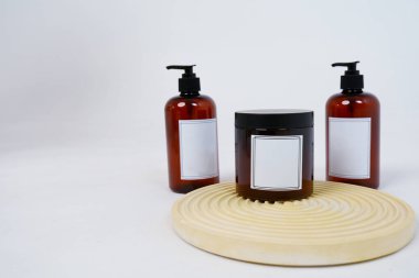 Vücut bakımı. Geometrik bir tezgahta açık gri arka planda, üzerinde şeker kutusu ve bir kavanoz vücut kremi olan iki şişe. Reklam konsepti. Yüksek kalite fotoğraf