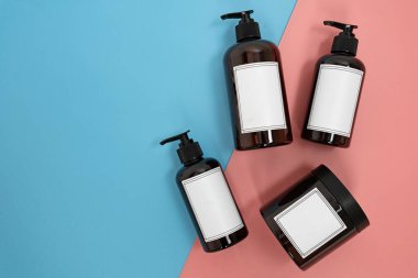 Vücut bakımı. Mavi ve pembe arka planda şeker kutuları ve krem kavanozları olan şişeler. Reklam konsepti. Yüksek kalite fotoğraf