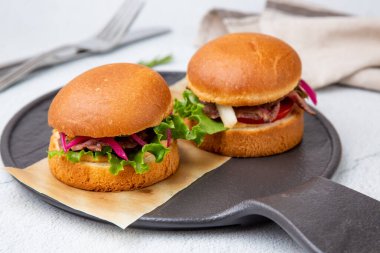 Tahtada salatalı ve sebzeli sıcak hamburger. 