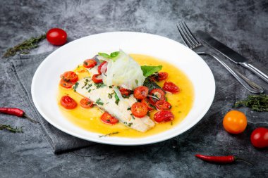 Sos, ot, vişneli domates ve soğanlı soyulmamış balık.