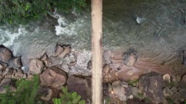 Brezilya ormanındaki yaya köprüsünün yukarıdan görünüşü altında güçlü bir nehir var.