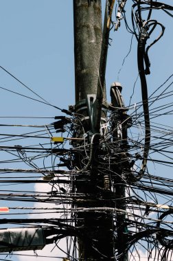 Elektrik direğine bağlı birçok kablo, elektrik direğindeki kablolar ve kablolar karmaşası, mavi gökyüzü arka planı, Brezilya 'daki teknolojik kombinasyon konsepti