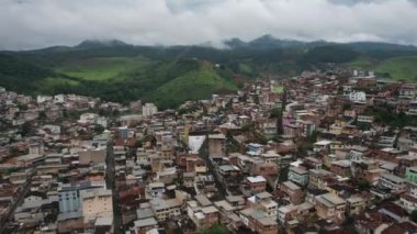 Manhuacu, Minas Gerais, Brezilya 'da kenar mahalle ya da gecekondu mahallesinde arka planda bulutlu hava aracı görüntüsü
