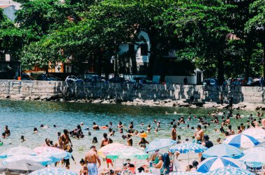 Rio de Janeiro, Brazil - January 17, 2023: View of people at Urca beach in Rio de Janeiro, Brazil on a summer day