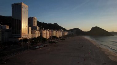 Aerial drone view over Leme Beach in the Copacabana District, Rio de Janeiro, Brazil at dusk. Sugarloaf mountain is barely visible in the background