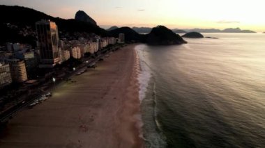 Aerial drone view over Leme Beach in the Copacabana District, Rio de Janeiro, Brazil at dusk. Sugarloaf mountain is barely visible in the background