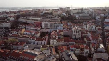 Revealing drone shoot of Bairro Alto and surrounding urban landscape, including 25 April Bridge in Lisbon, Portugal