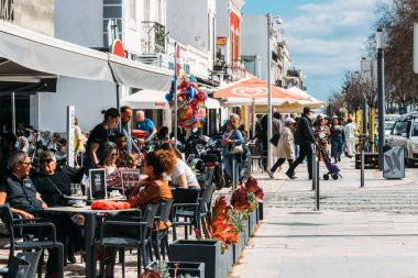 Olhao, Portekiz - 18 Mart 2023: Olhao, Algarve, Portekiz 'de insanlar teraslarda dinleniyor