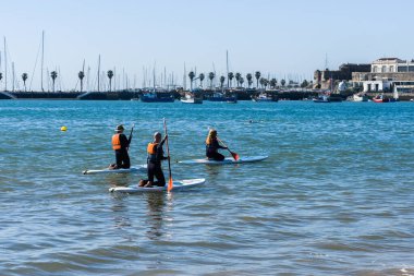 Cascais, Portekiz - 25 Mart 2023: Yazın Cascais Körfezi 'nde ayakta kürek çeken insanlar