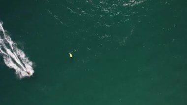 Hızlı jet ski 'nin en tepedeki hava aracı görüntüsü suda bir iz bırakarak viraj yapıyor, Vilamoura, Algarve, Portekiz' de yakalandı.