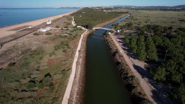 在一个阳光灿烂的日子里 一架无人驾驶飞机从葡萄牙维拉莫拉的普拉亚 德法里塞斯旁边的一条运河俯瞰着前方 — 图库视频影像