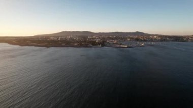 Portekiz 'deki Cascais Körfezi' nin insansız hava aracı görüntüsü deniz fenerine ve marinaya yaklaşıyor. Arka planda Sintra dağları var.