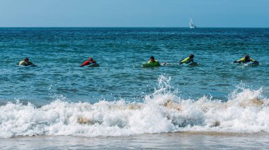 Carcavelos, Portekiz - 15 Eylül 2023: Lizbon, Portekiz yakınlarındaki Carcavelos plajında bir grup genç sörfçü