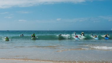 Carcavelos, Portekiz - 15 Eylül 2023: Lizbon, Portekiz yakınlarındaki Carcavelos plajında bir grup genç sörfçü