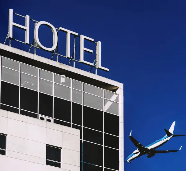 Reise Und Hotelkonzept Eines Flugzeugs Neben Einem Gebäude Mit Hinweisschild — Stockfoto
