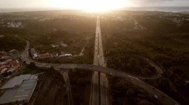 Cascais, Portekiz 'deki A5 otoyolunun gün batımında hava aracı POV takibi.