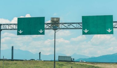 Arka planda dağlar olan otoyolun yanındaki işaretler, kırsal ulaşım kavramı