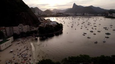 Rio de Janeiro, Brezilya 'daki Botafogo Körfezi' ne yaklaşan hava aracı gün batımında ikonik İsa 'yla birlikte görülüyor. Kurtarıcı Heykeli UNESCO Dünya Mirası Alanı