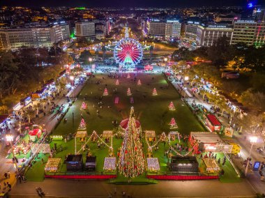 Lizbon, Portekiz - 23 Aralık 2024: Eduardo XII Park 'taki Wonderland Lisbon Noel süslemelerinde büyük bir dönme dolap ve temalı dükkanların hava aracı görüntüsü