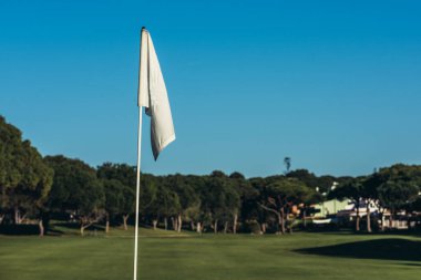 İyi korunan bir golf sahasında Portekiz 'in Algarve şehrinde açık mavi gökyüzü altında canlı yeşil bir çim yolu sergileniyor.